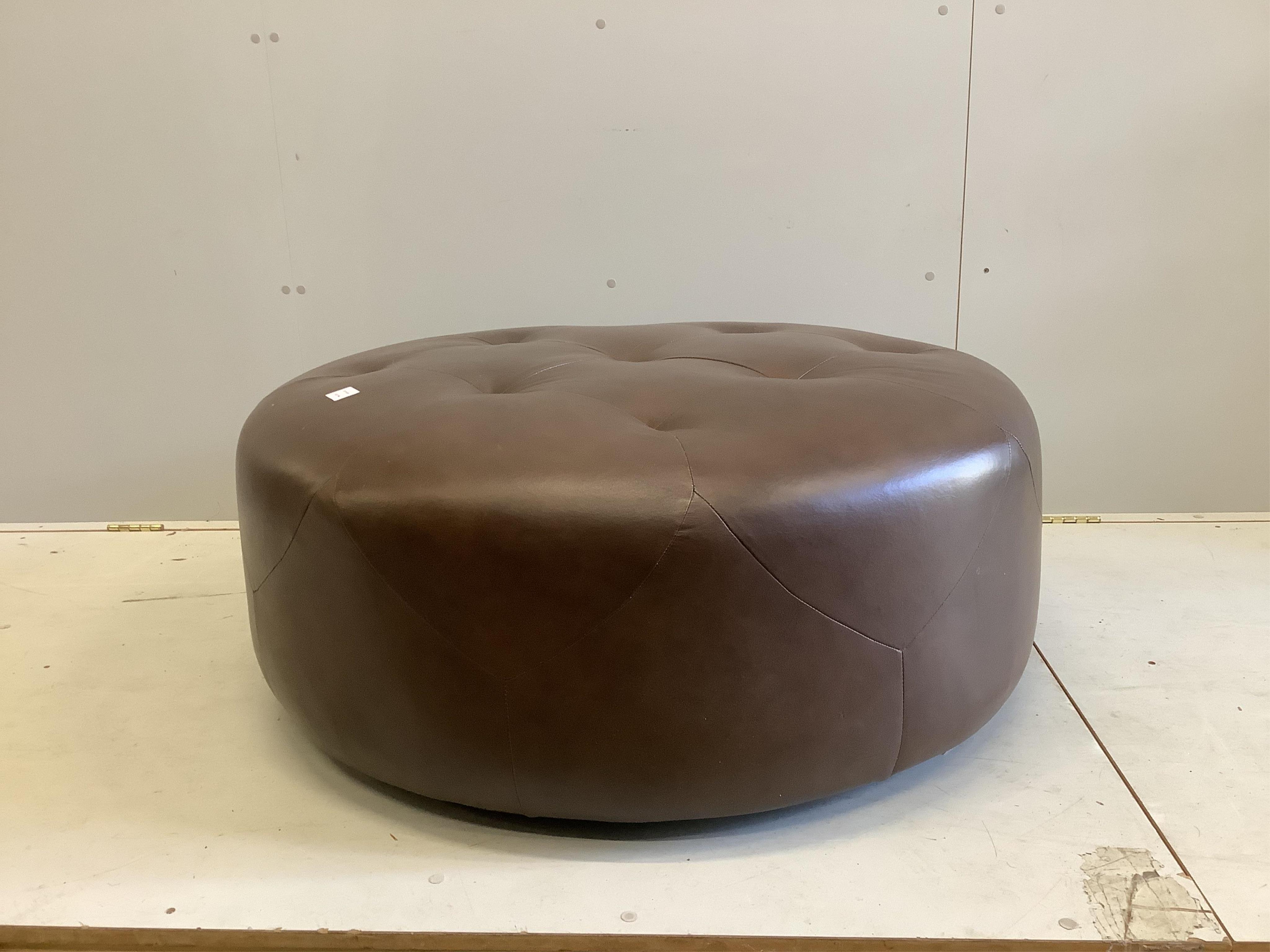 A circular brown leather footstool, diameter 100cm, height 36cm. Condition - fair